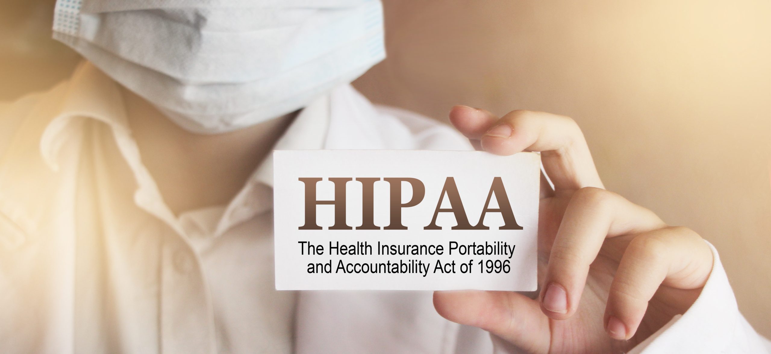 photo of a person wearing a surgical mask displaying a business card with 'HIPAA' written on it, symbolizing the barriers created by HIPAA for families trying to access confidential medical information of their loved ones with severe mental illness