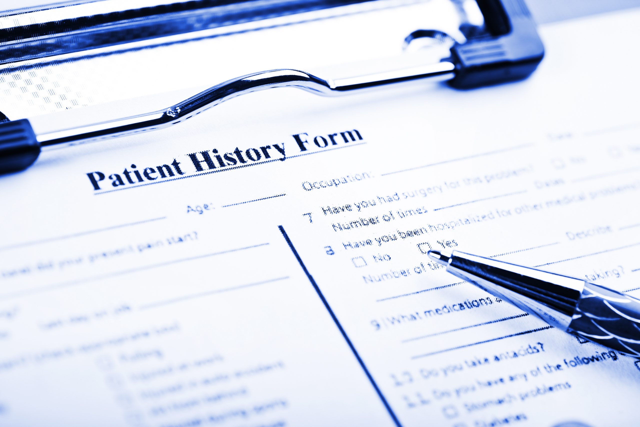 Close-up of a patient history form with a pen, representing the importance of collecting and organizing mental health histories for individuals with severe mental illness to improve care and outcomes